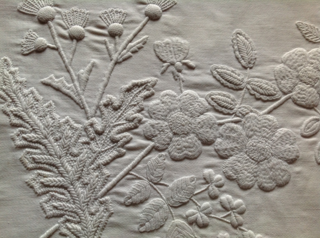 Close-up of detailing on a mountmellick piece, including leaves and plants